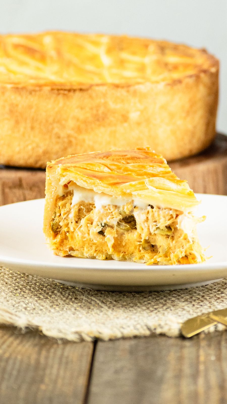 Fatia de torta salgada de frango com massa dourada e requeijão da Damari Doces