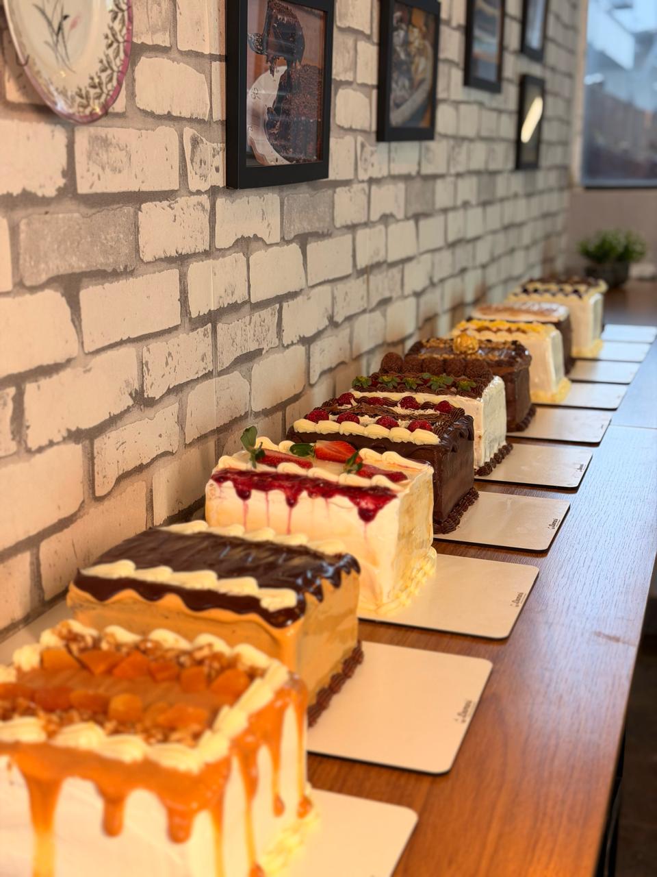 Vitrine com bolos de diferentes sabores e coberturas da Damari Doces