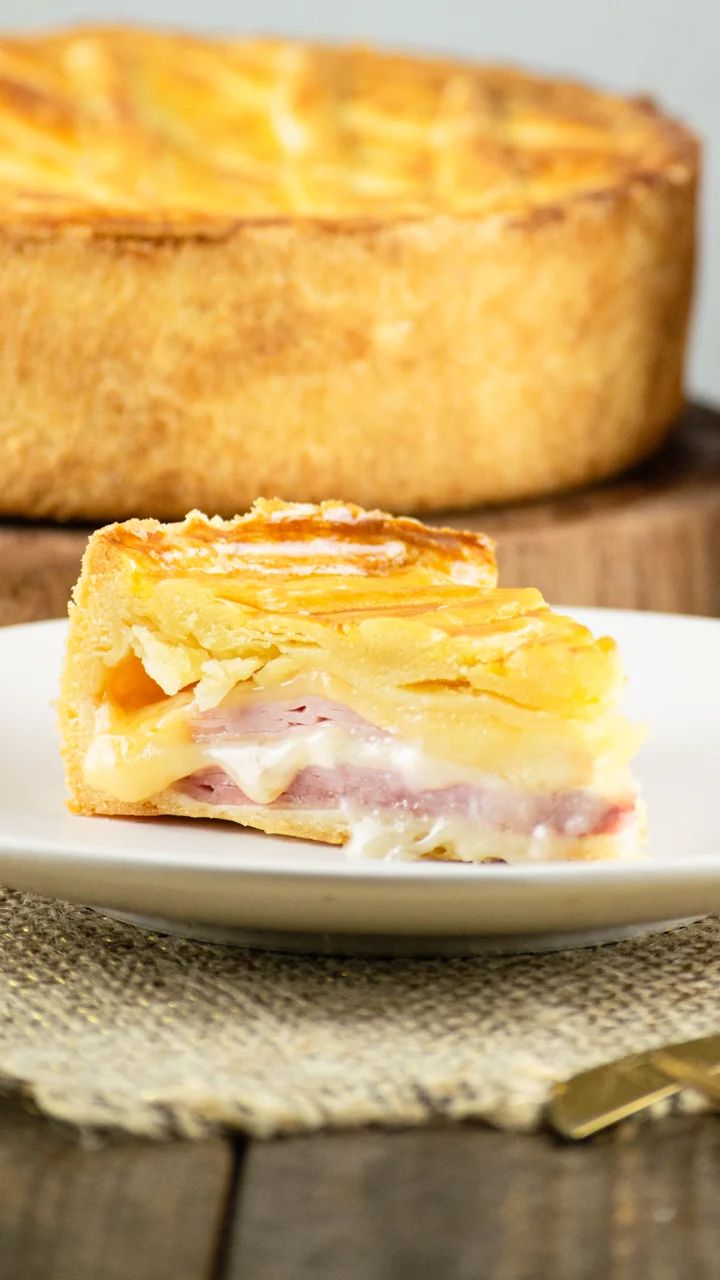 Fatia de torta salgada de presunto e queijo com massa dourada da Damari Doces